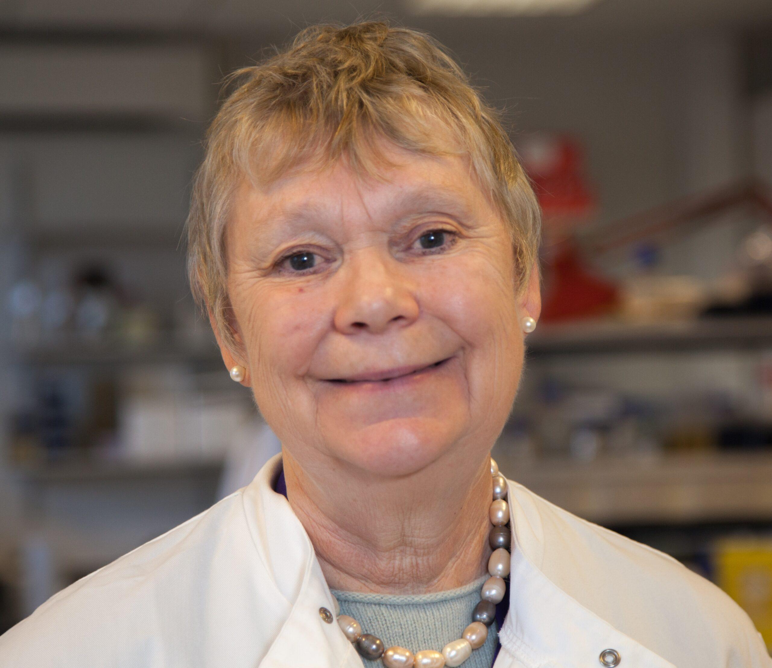 Headshot of Professor Fran Balkwill in the laboratory wearing a white laboratory coat.